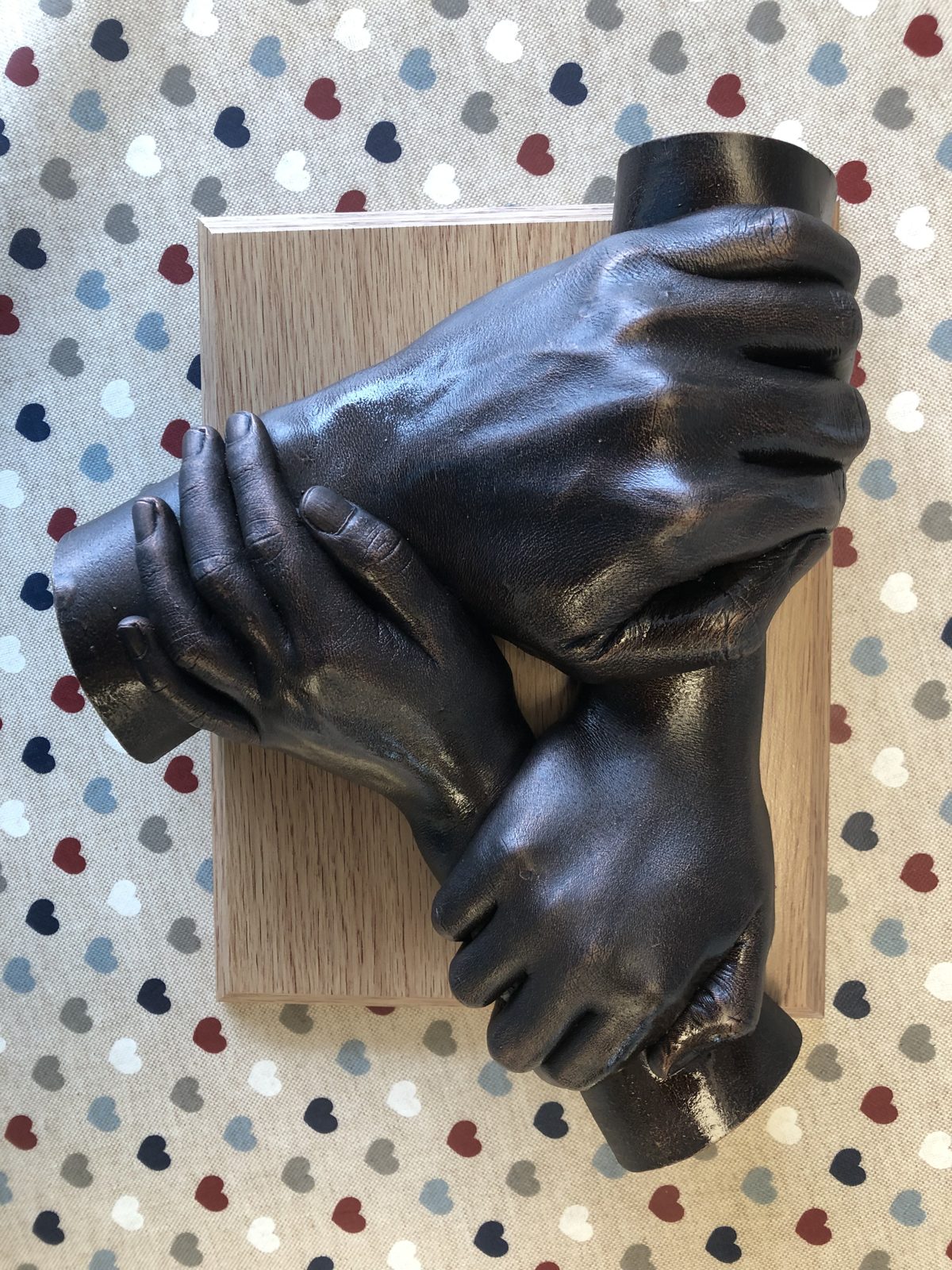 Bronze-glazed cast of a whole family's hands entwined