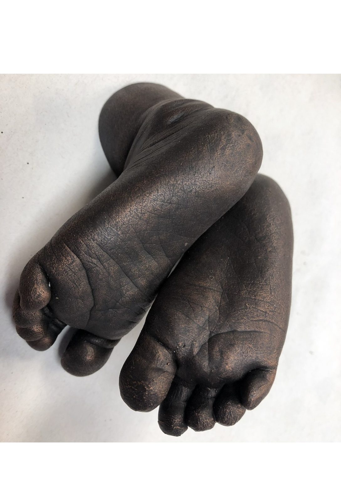 Bronze-glazed cast of two baby feet