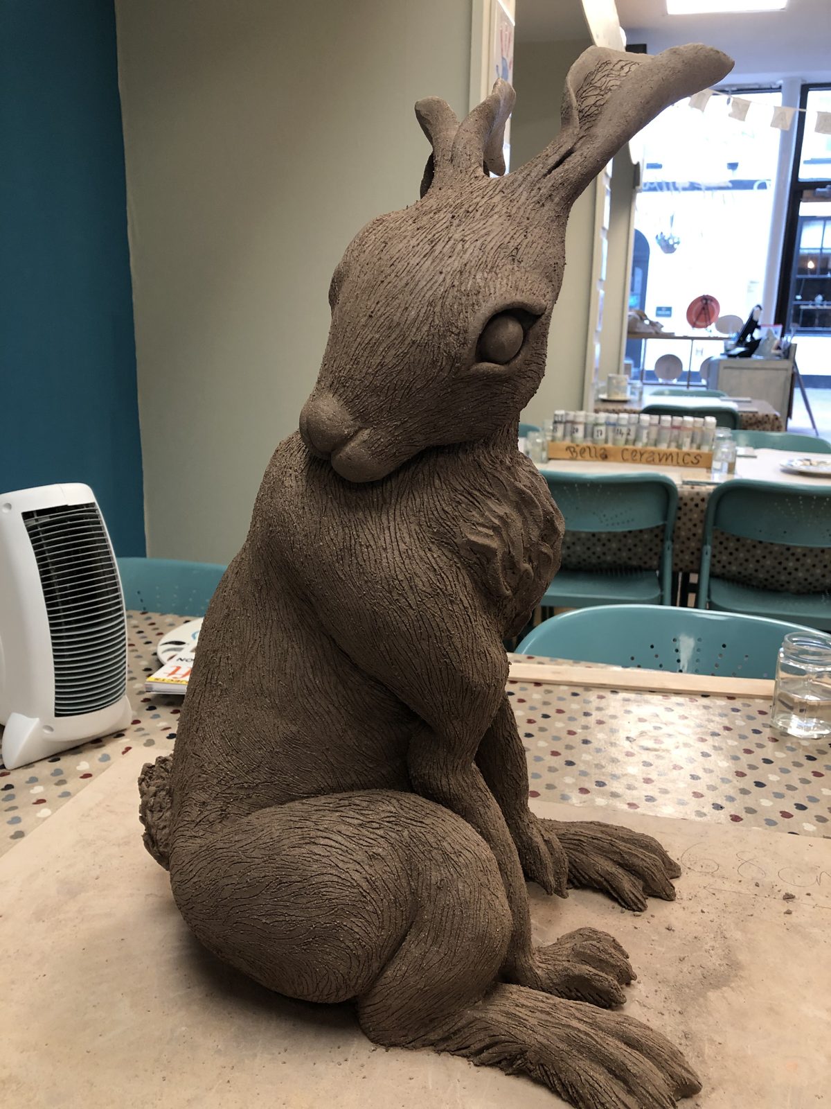 Life-size clay hare sitting upright
