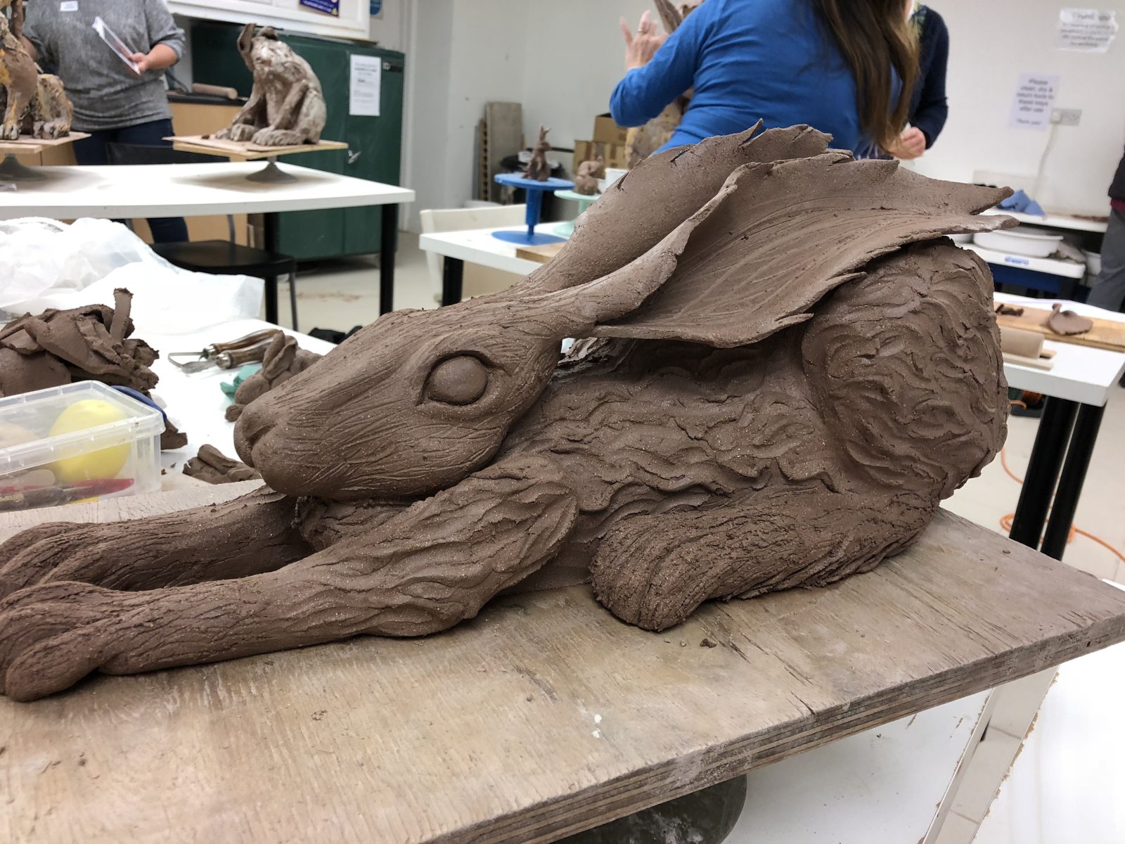 A large clay hare resting on the workshop table