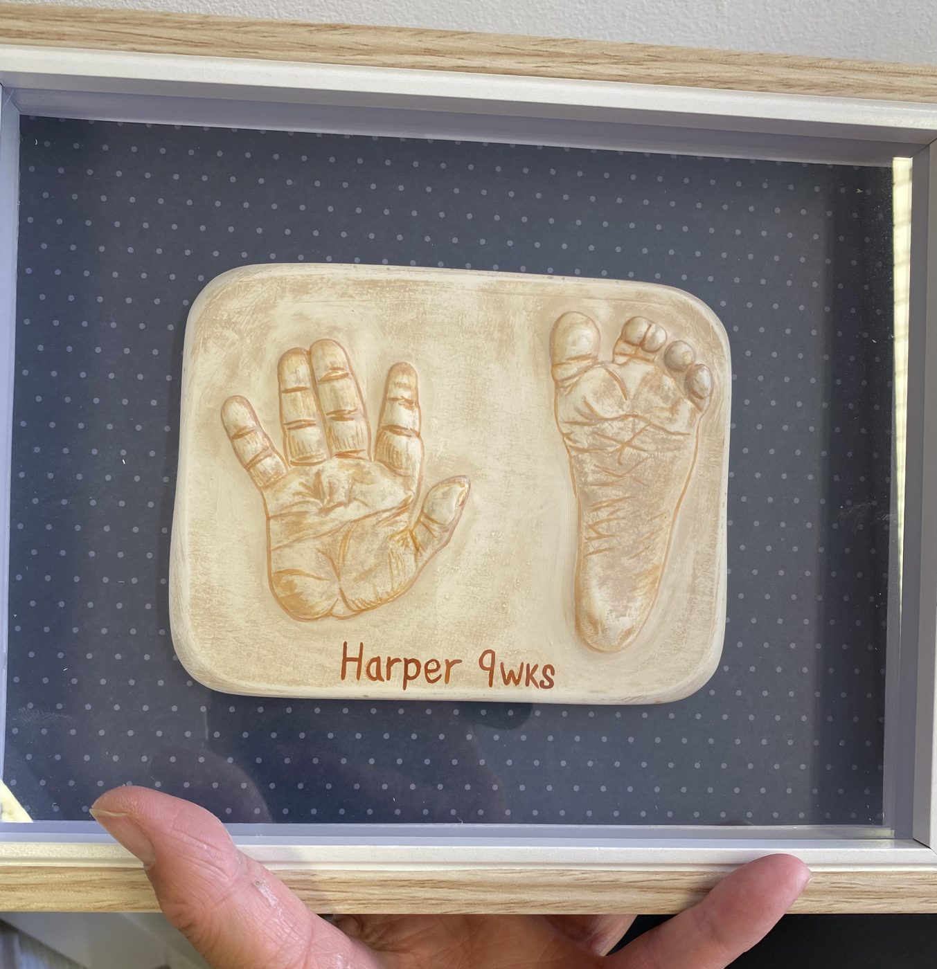 Framed raised cast of a baby hand and foot