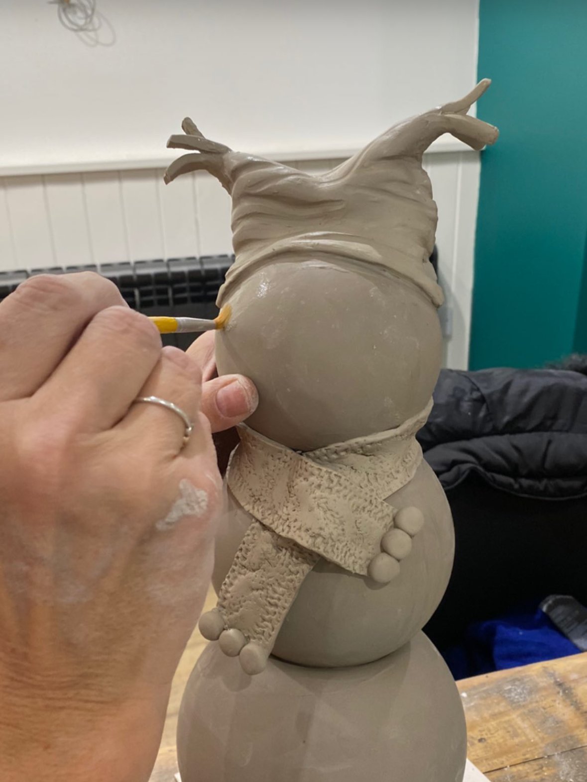 Jo shaping a clay figure in the studio