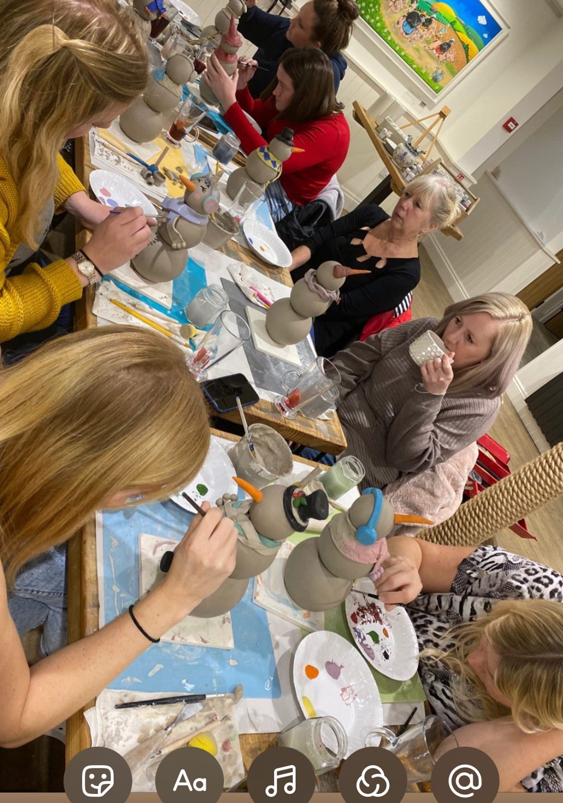 Children painting clay snowmen at the big table
