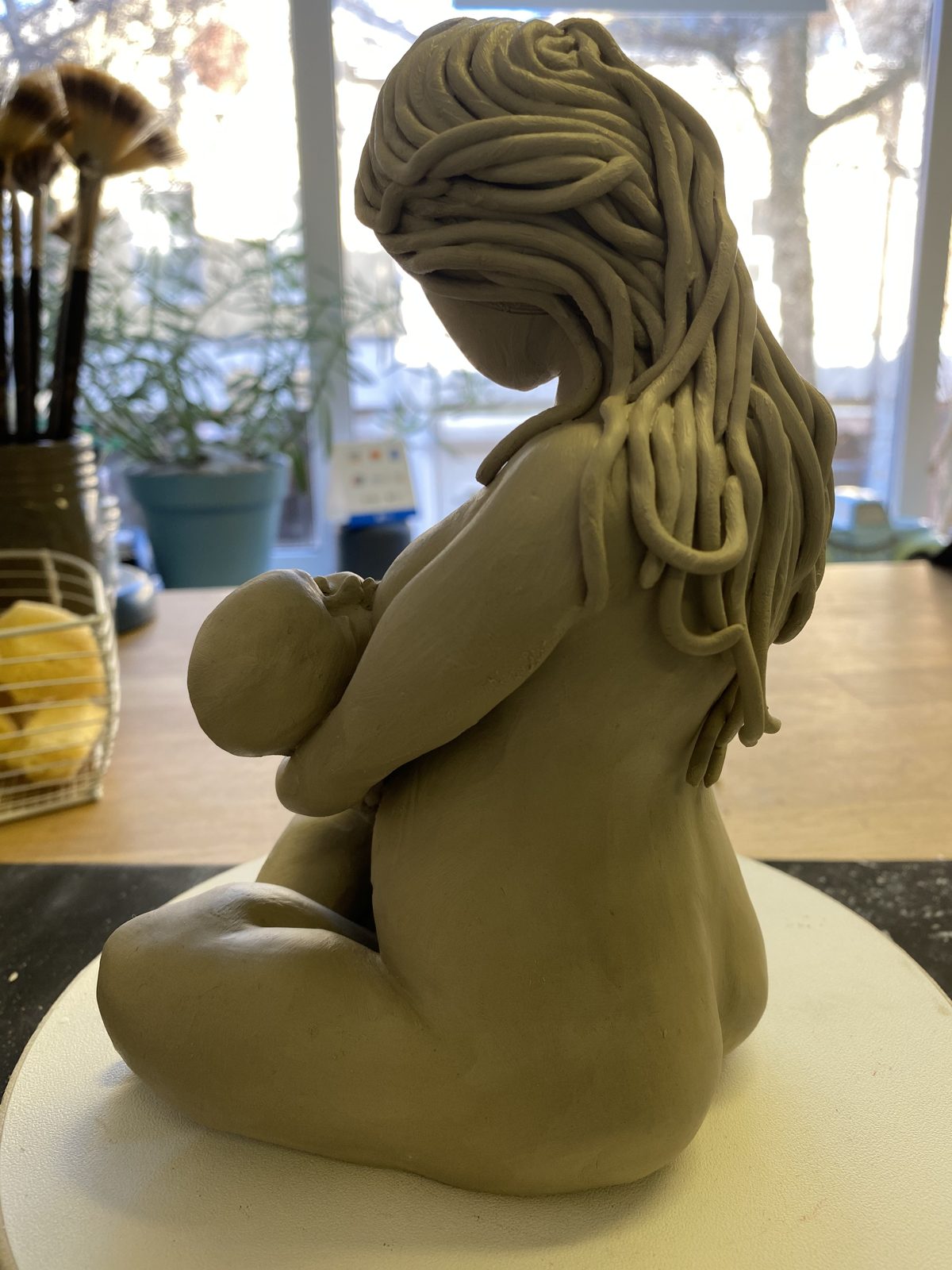 Clay sculpture of a mother holding a baby
