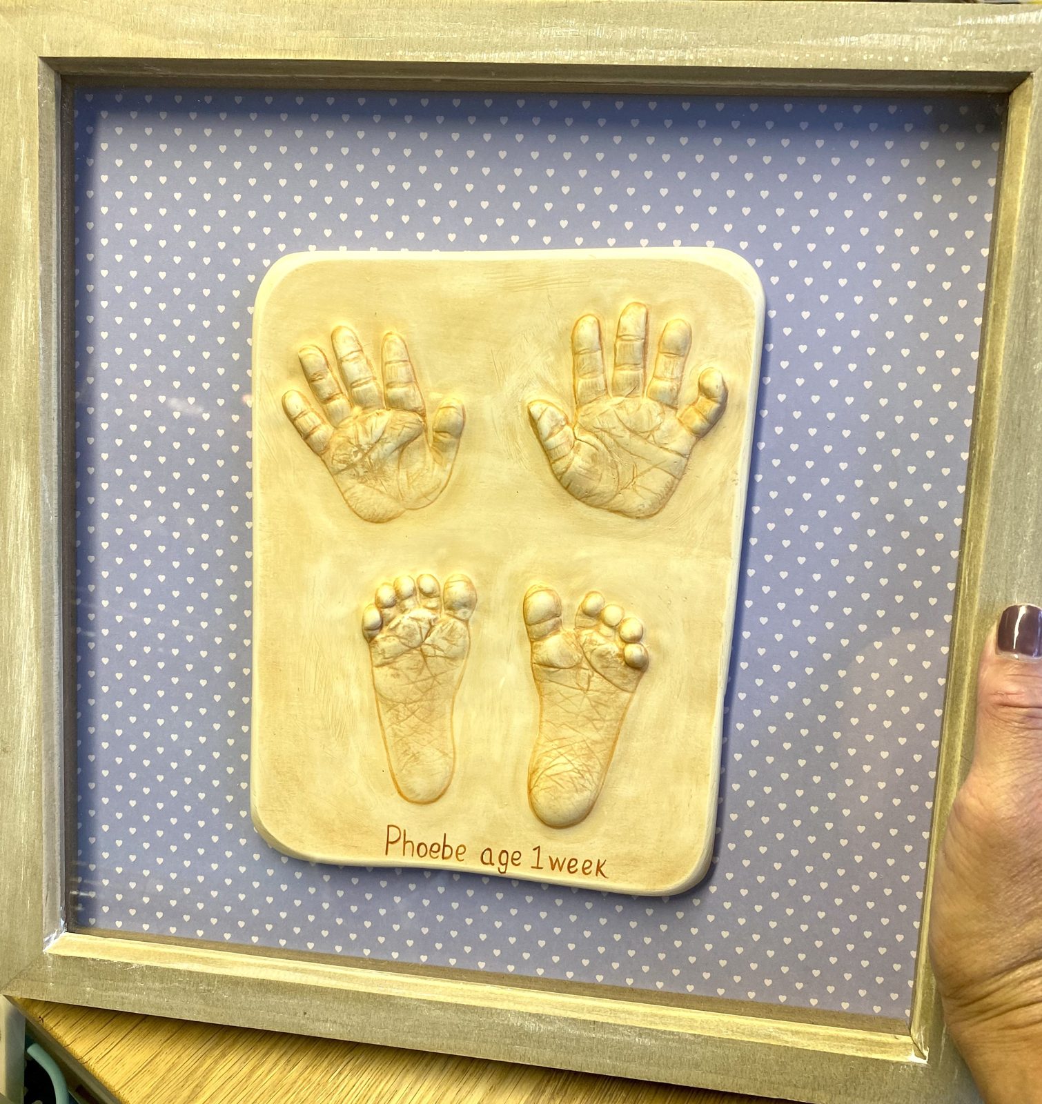Raised casts of two hands and two feet in an oak frame