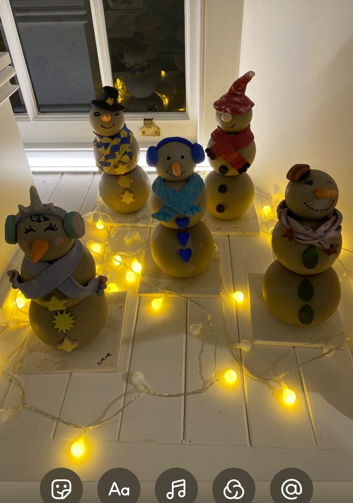 Clay snowmen with fairy lights after their first firing